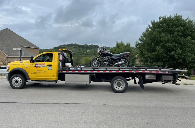 Motorcycle strapped to a flatbed tow truck